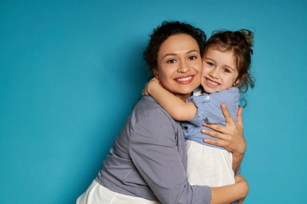 mother hugging her child after a spider vein treatment for face, happy and cheerful